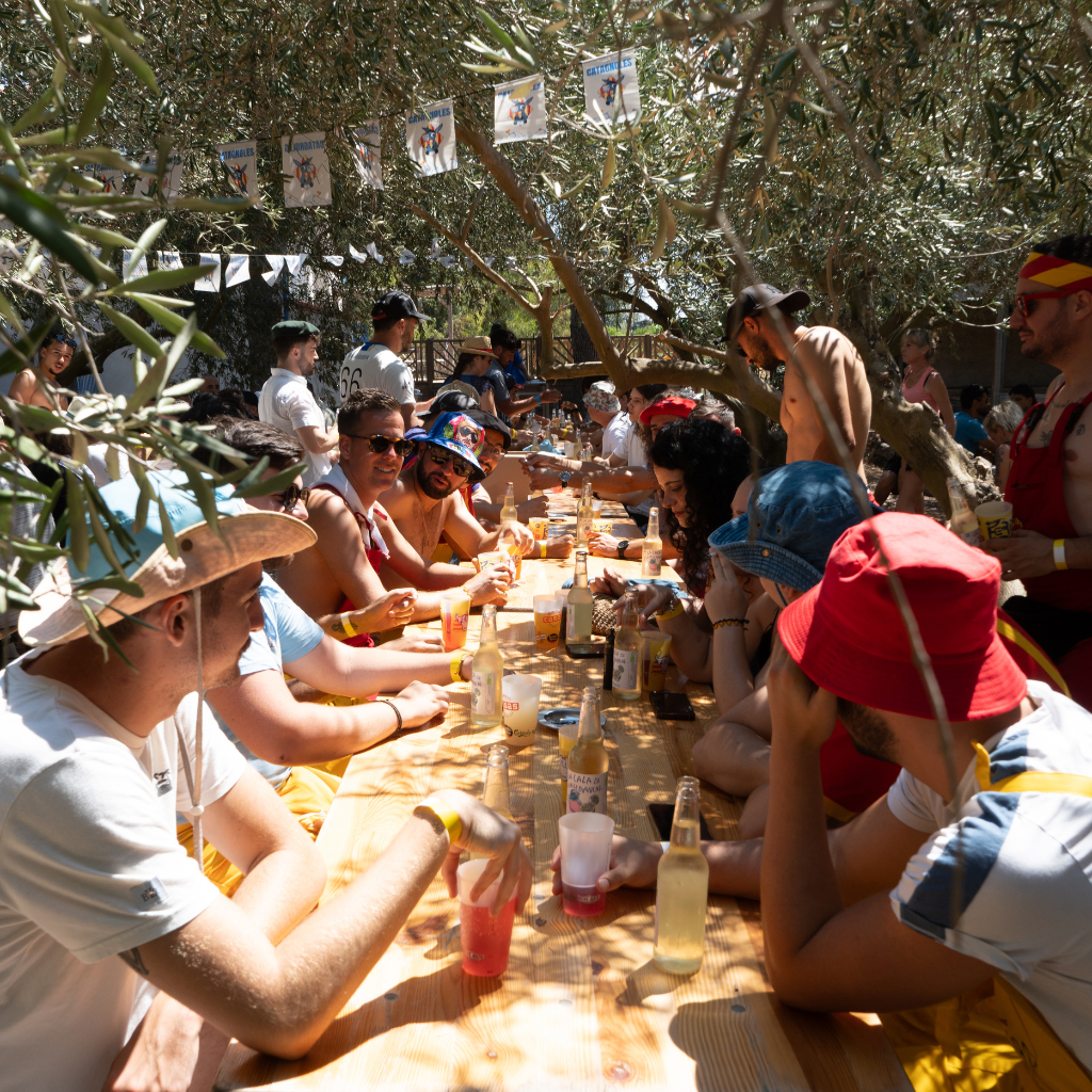 Photo dans laquelle nous pouvons voir des personnes autour d'une table entrain de profiter d'un grand repas, il y a une ambiance très conviviale 